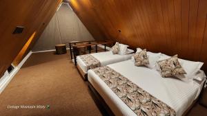 two twin beds in a room with wood walls at Cottage Mountain Misty-Nuwaraeliya in Nuwara Eliya