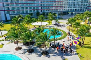 an aerial view of a resort with palm trees and a pool at J Home The Arena Cam Ranh in Cam Ranh International Airport