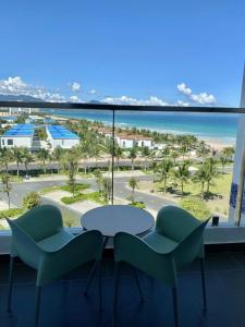 a table and chairs in a room with a view of the ocean at J Home The Arena Cam Ranh in Cam Ranh International Airport