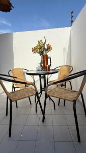 a black table with chairs and a vase on it at Increible Departamento en Ciudad de Mendoza, a metros de Parque Central y proximo a microcentro con cochera Pellegrini Apartments Parque Central in La Cieneguita