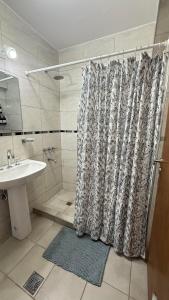 a shower curtain in a bathroom with a sink at Increible Departamento en Ciudad de Mendoza, a metros de Parque Central y proximo a microcentro con cochera Pellegrini Apartments Parque Central in La Cieneguita +35 photos