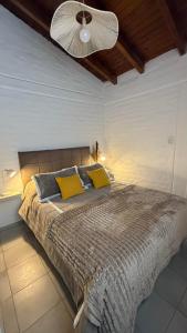 a bedroom with a large bed with yellow pillows at Increible Departamento en Ciudad de Mendoza, a metros de Parque Central y proximo a microcentro con cochera Pellegrini Apartments Parque Central in La Cieneguita