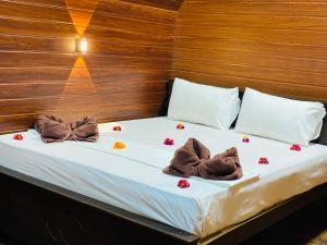 two towels on a bed with flowers on it at The Warming Nest Tree House in Sigiriya +13 photos