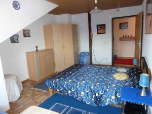 ランゲナルゲンにあるFerienwohnung Blütenmeerのベッドルーム1室(青い掛け布団付きのベッド1台付)