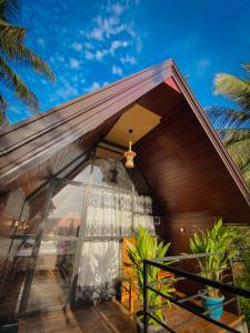 a house with a large window on a deck at The Warming Nest Tree House in Sigiriya