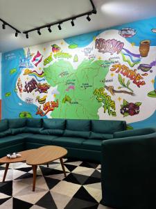 een woonkamer met een groene bank en een kaart bij Mangueirosa Hostel in Belém