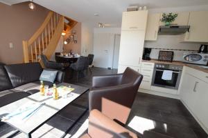 Una sala de estar y una cocina con mesa y sillas. en Greta, en Norddeich
