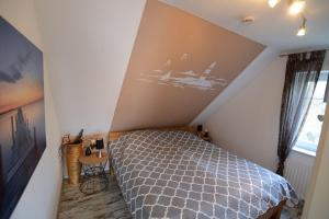 Un dormitorio con una cama con un cuadro en la pared. en Greta, en Norddeich