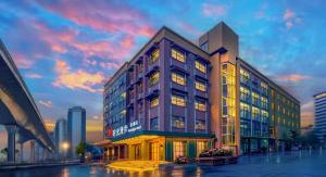 ein großes Gebäude in einer Stadt bei Sonnenuntergang in der Unterkunft Nost algia S Hotel Shanghai Fudan University 时光漫步S酒店上海复旦大学五角场地铁站店 Free fresh ground coffee,Free laundry service in Shanghai