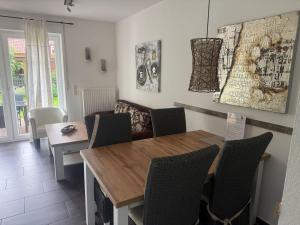 Un comedor con mesa y sillas de madera. en Taddel, en Norddeich
