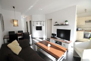 una sala de estar con un sofá y una mesa en Taddel, en Norddeich