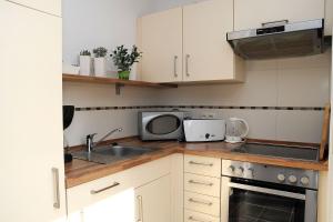 una cocina con fregadero y microondas en Taddel, en Norddeich 5 fotos más