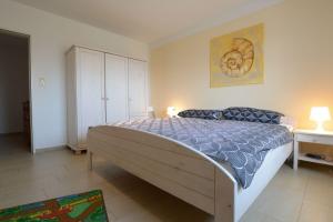 - une chambre avec un grand lit et une armoire blanche dans l'établissement Feldblick-im-Landhaus-Haan, à Norden