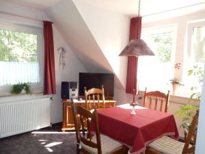 uma sala de jantar com uma mesa vermelha e cadeiras em Haus Elvira em Horb am Neckar