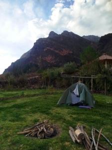 a tent in a field with a mountain in the background at Bearded Moutaineer sacred garden & lodge in San Salvador