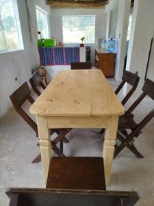 a wooden table and chairs in a room at Bearded Moutaineer sacred garden & lodge in San Salvador