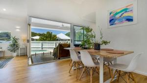una sala da pranzo con un tavolo e sedie bianche di Bangalow Breeze - Lovely Pool - Walk to Centre a Bangalow