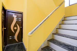 a wooden door with a painting on it next to stairs at Hotel O The Avenue Inn in Nager Bazaar