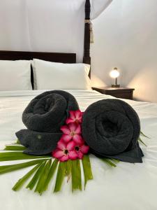 two towels and flowers on top of a bed at Will and Ray's at Lori Beach Inn in Seminyak +7 photos