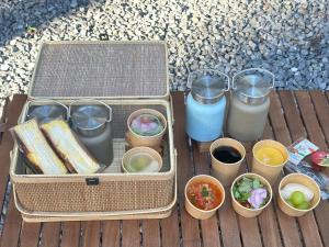 a lunch box with food and drinks on a wooden table at Render Fika Sammu in Sanmu