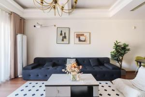 a living room with a blue couch and a table at 重庆云邸-江景格调公寓 in Chongqing +68 photos
