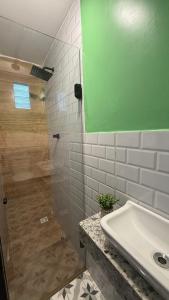 een badkamer met een wastafel en een glazen douche bij Mangueirosa Hostel in Belém