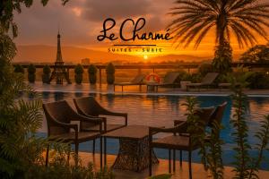 a sunset over a pool with chairs and the eiffel tower at Le Charmé Suites - Subic in Olongapo
