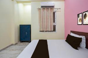 a bedroom with a large bed with pink walls at Hotel O BLISS INN in Chinhat +22 photos