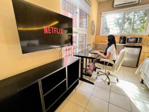 a woman sitting in a chair at a desk with a laptop at Loft Moderno #2 in Puerto Barrios