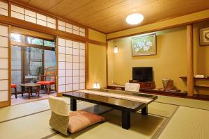 a living room with a table and a tv at Yanagiso in Toyooka