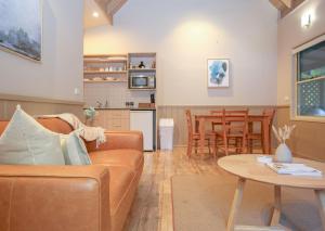a living room with a couch and a table at Autumn Leaf Cottage 2 in Harrietville