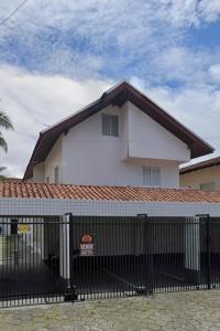 a white building with a fence in front of it at Sobrado em Caiobá in Matinhos