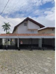 a house with a fence in front of it at Sobrado em Caiobá in Matinhos