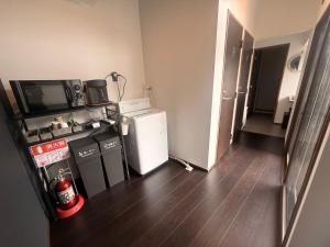 eine kleine Küche mit Kühlschrank und Mikrowelle in der Unterkunft Zenya-Nakano in Nakano