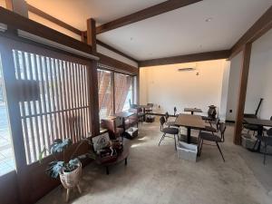 ein großer Raum mit Tischen und Stühlen und Fenstern in der Unterkunft Zenya-Nakano in Nakano