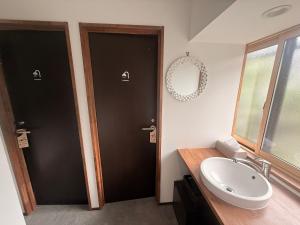 ein Badezimmer mit zwei schwarzen Türen und einem Waschbecken in der Unterkunft Zenya-Nakano in Nakano