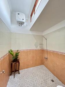 a bathroom with a shower and a plant on a table at Will and Ray's at Lori Beach Inn in Seminyak +7 photos