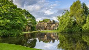 a castle with a lake in front of it at Canalside Riddlesden, 2 Bedroom house with parking Easy access to Skipton Haworth Ilkley Saltaire and Keighley Worth Valley Railway in Keighley