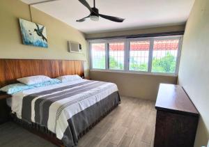 a bedroom with a bed and a ceiling fan at Casa Cactus - 2-Story Home with Garden and Pool in Puerto Escondido