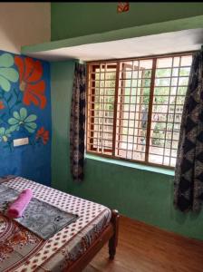 a bedroom with green walls and a bed and windows at Ever green home stay in Alleppey