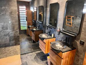 une salle de bain avec trois lavabos et deux miroirs dans l'établissement La villa Blue Banian, à Saint-Pierre 32 autres photos