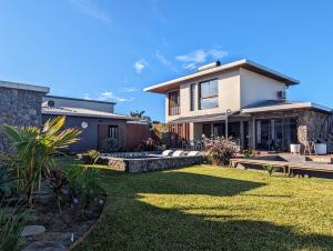 une maison avec une pelouse devant dans l'établissement La villa Blue Banian, à Saint-Pierre