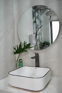 un lavabo blanc dans une salle de bain avec un miroir dans l'établissement Kim Homestay in Hue, à Thôn Lại Thê