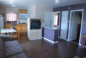 a living room with a couch and a tv and a kitchen at Royal Court Motel in Wildwood