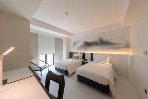 a hotel room with two beds and a chair at Chien Tang Art Hotel  +2 photos
