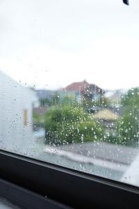 une fenêtre imprégnée de pluie avec vue sur la ville dans l'établissement Kim Homestay in Hue, à Thôn Lại Thê 9 autres photos