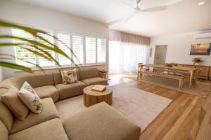 a living room with a couch and a table at Aloha Byron Bay in Byron Bay