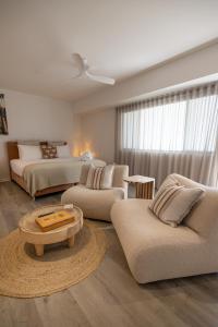 a living room with two beds and a couch and a table at Aloha Byron Bay in Byron Bay +114 photos