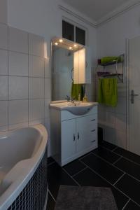 a bathroom with a tub and a sink and a mirror at Flataid Apartment Elisabethinergasse in Graz