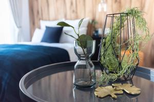 a table with a glass vase and flowers on it at Villa Penthouse Tenma in Osaka